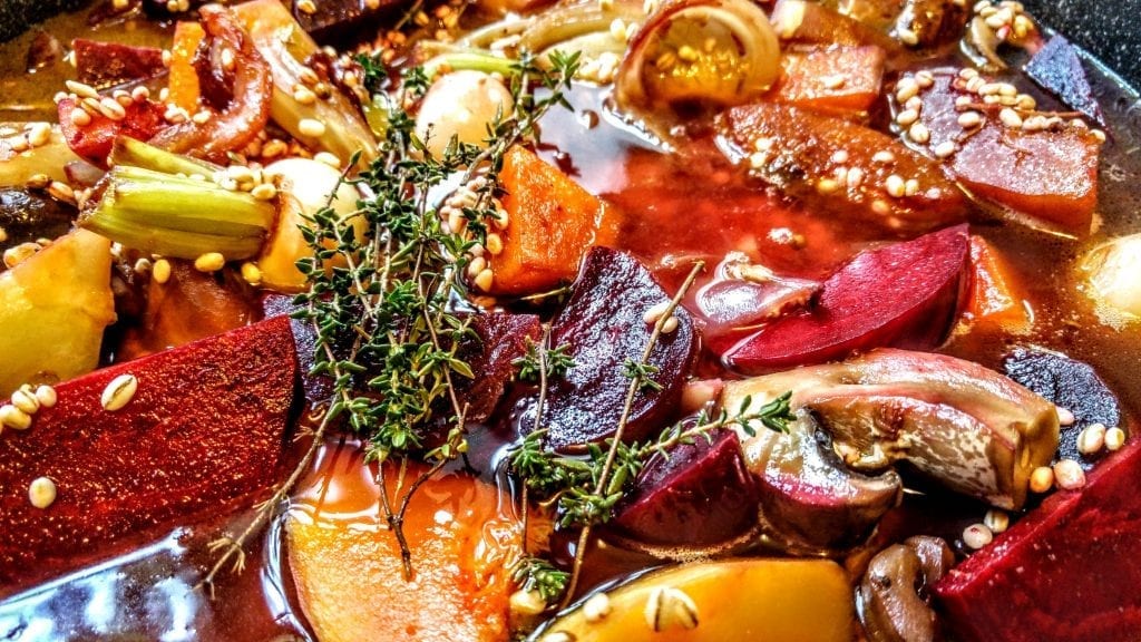 קדירת חורף טבעונית של פטריות וירקות שורש עם גריסי פנינה